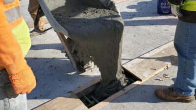 Ultra-High Performance Concrete (UHPC) being poured between the griders.